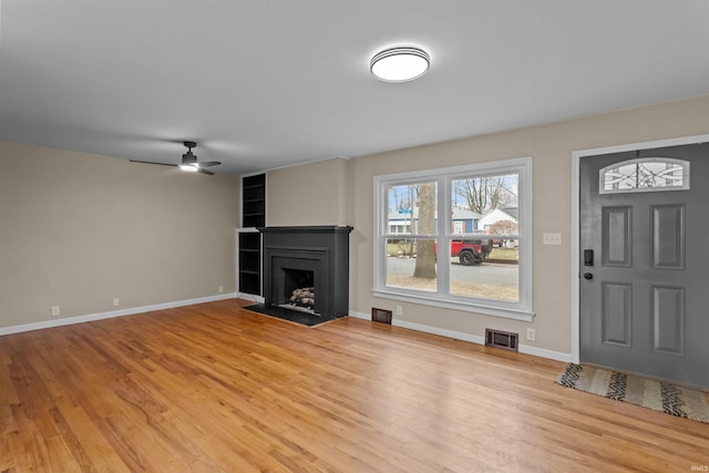 unfurnished living room featuring ceiling fan and light wood-type flooring