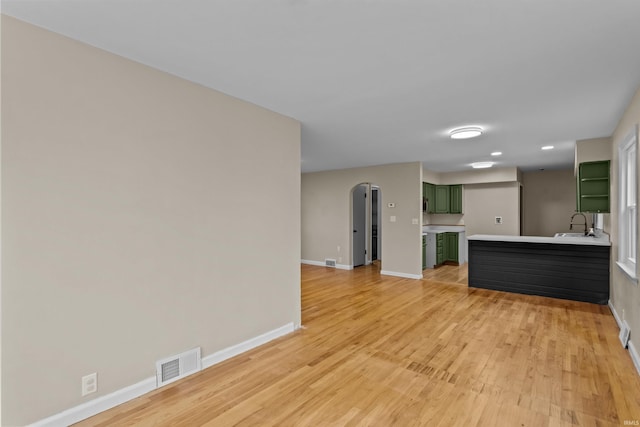 unfurnished living room with sink and light wood-type flooring