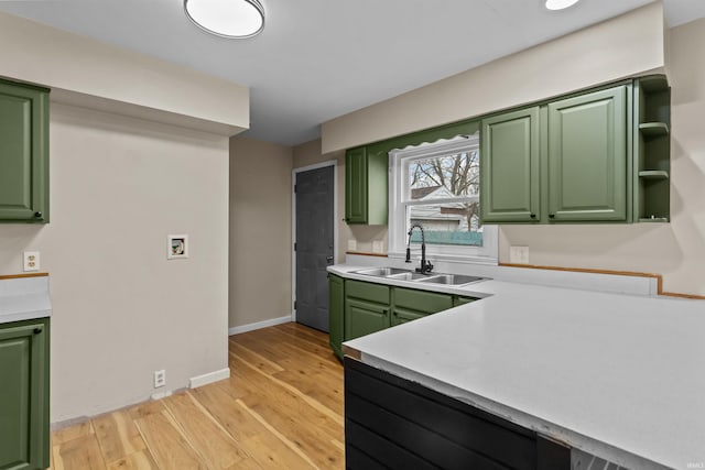 kitchen with sink, light hardwood / wood-style floors, and green cabinetry