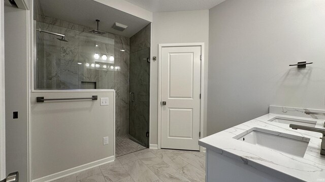 bathroom with baseboards, a marble finish shower, double vanity, a sink, and marble finish floor