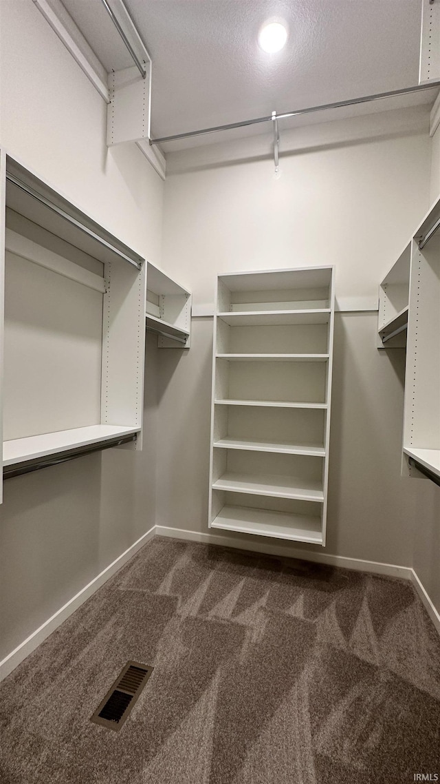 spacious closet featuring visible vents and dark carpet