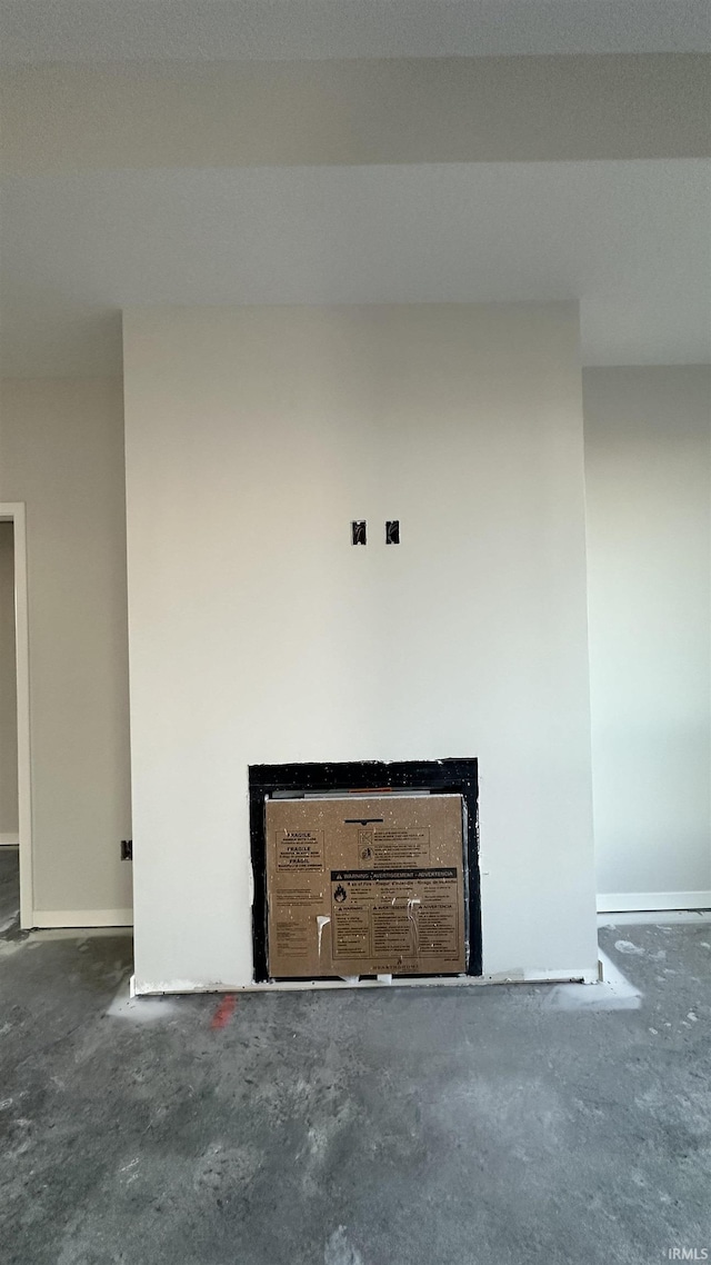 room details featuring baseboards and unfinished concrete flooring