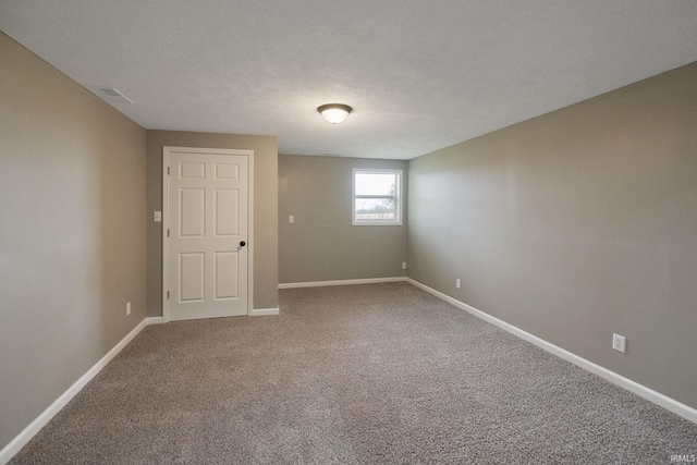 unfurnished room with carpet floors and a textured ceiling