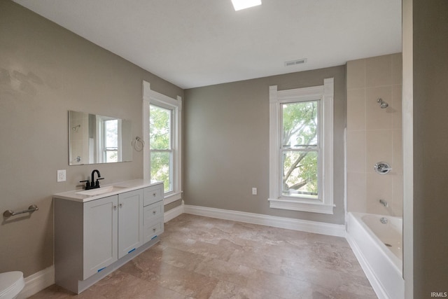 full bathroom featuring vanity, toilet, and tiled shower / bath