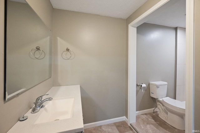 bathroom with sink, a textured ceiling, and toilet