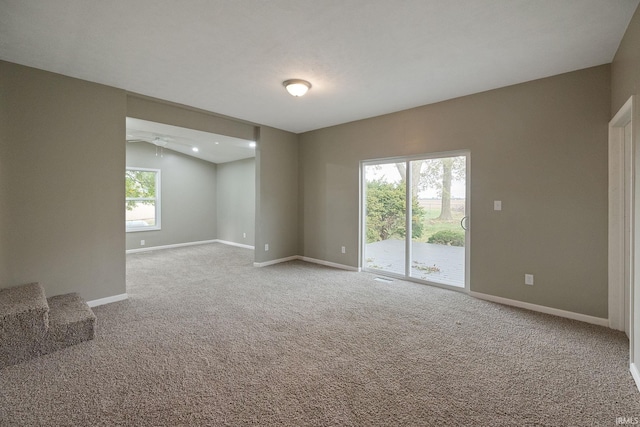 carpeted spare room featuring lofted ceiling