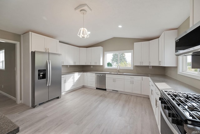 kitchen featuring appliances with stainless steel finishes, decorative light fixtures, sink, white cabinets, and a healthy amount of sunlight