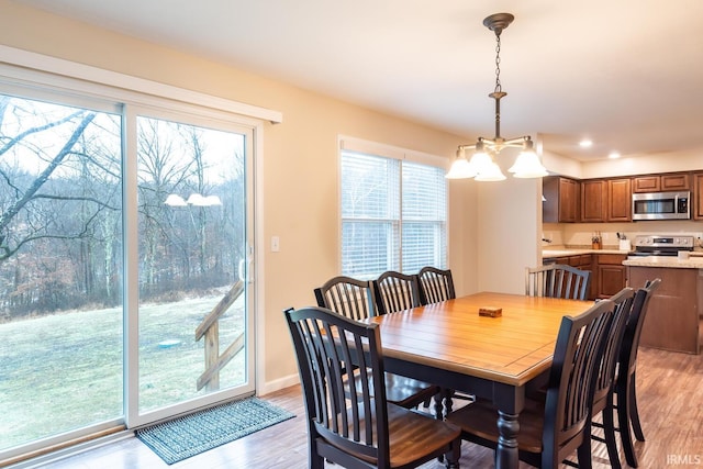 dining area with a notable chandelier and light hardwood / wood-style floors