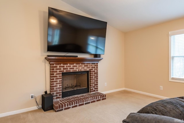 carpeted living room with a fireplace and vaulted ceiling