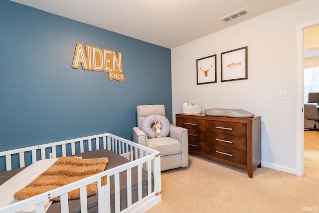 bedroom featuring a crib and light carpet