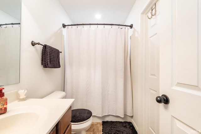 bathroom featuring walk in shower, vanity, and toilet