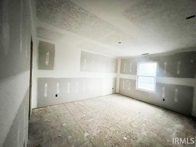 spare room with a textured ceiling