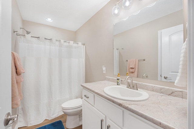 bathroom featuring hardwood / wood-style flooring, vanity, walk in shower, and toilet