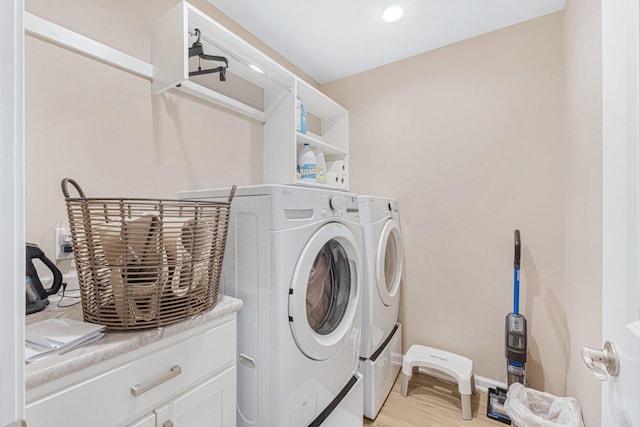 washroom with washing machine and dryer and light hardwood / wood-style floors