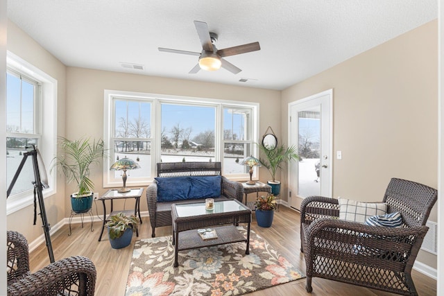 sitting room with a textured ceiling, light hardwood / wood-style flooring, and ceiling fan