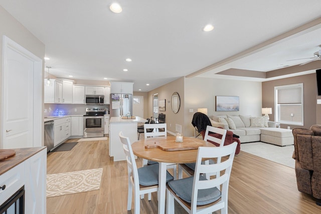 dining room with ceiling fan and light wood-type flooring