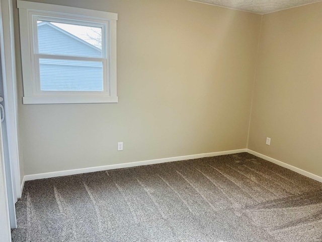 carpeted empty room featuring a textured ceiling