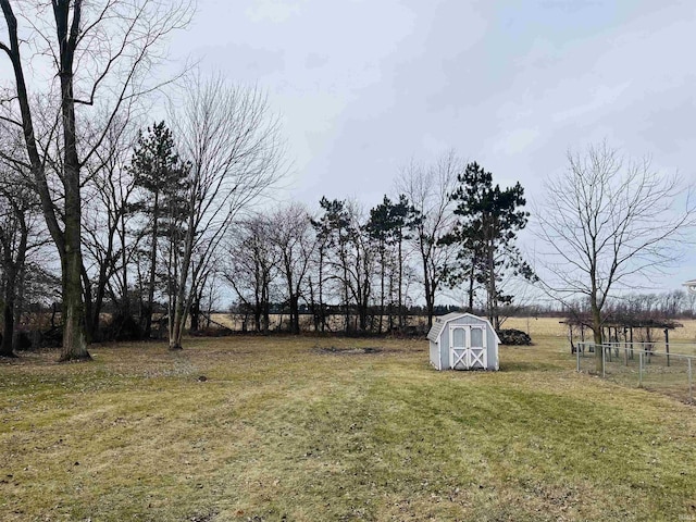 view of yard with a rural view and a storage shed