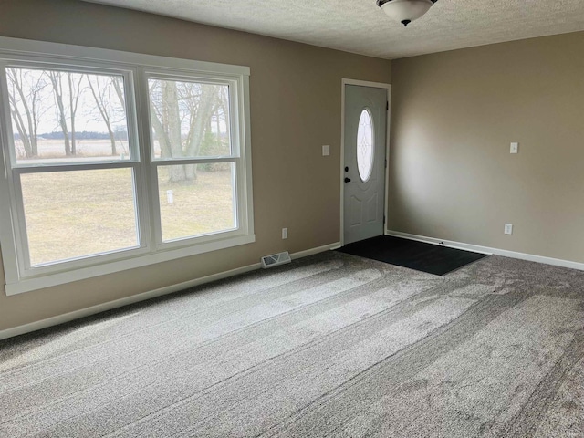 carpeted entryway featuring a textured ceiling