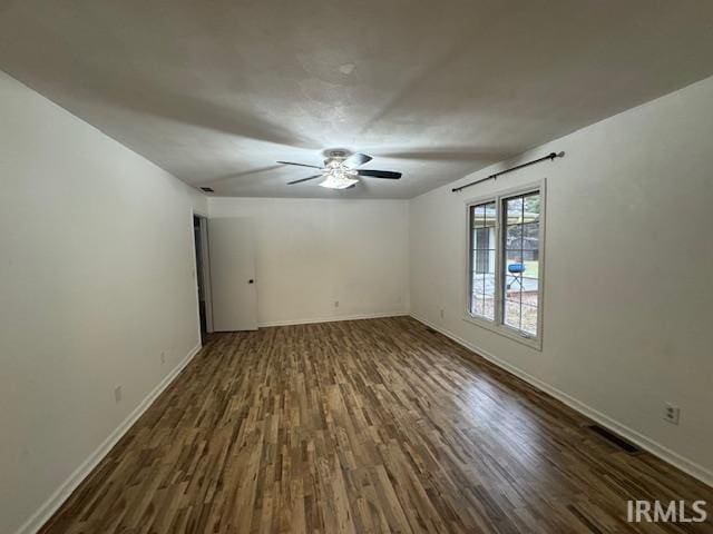 unfurnished room with dark wood-type flooring and ceiling fan