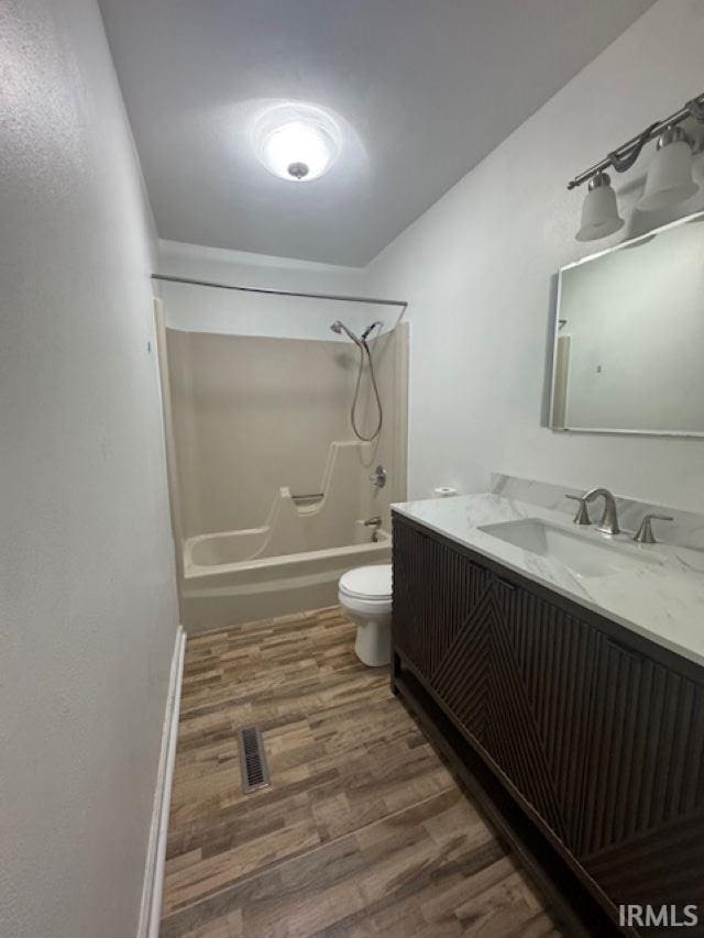 full bathroom featuring vanity, toilet, hardwood / wood-style floors, and shower / bathing tub combination