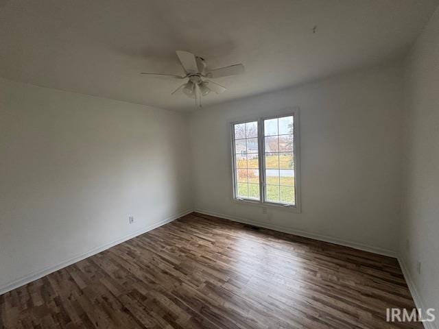 empty room with dark wood-type flooring and ceiling fan