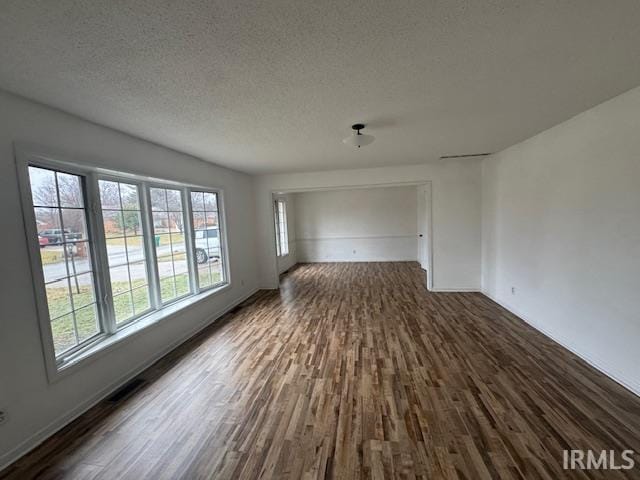 spare room featuring dark hardwood / wood-style floors and a textured ceiling