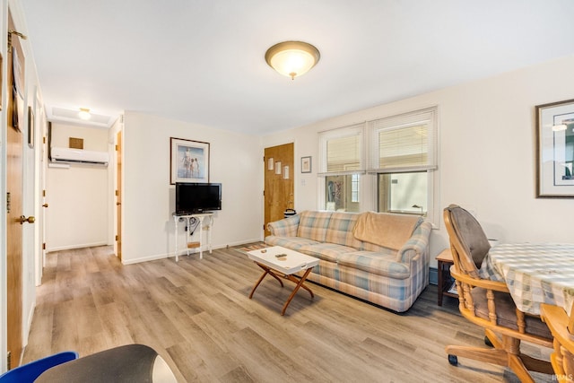 living room with a wall mounted air conditioner and light hardwood / wood-style floors