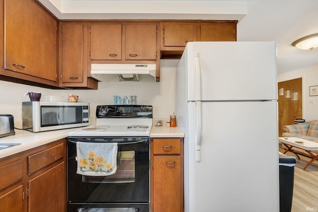 kitchen with white fridge, electric range, and light hardwood / wood-style flooring