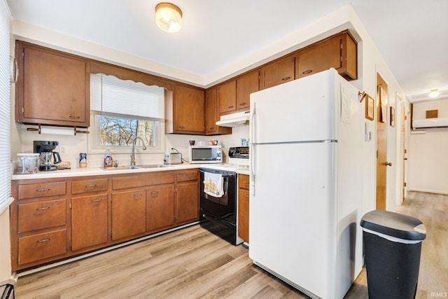 kitchen featuring range with electric cooktop, an AC wall unit, sink, white refrigerator, and light hardwood / wood-style flooring