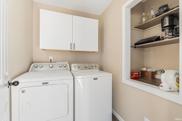 clothes washing area featuring cabinets and washing machine and dryer