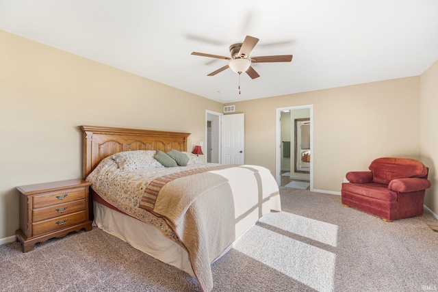 bedroom with light colored carpet, ceiling fan, and ensuite bath