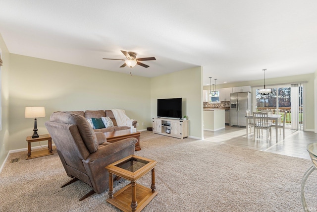 living room featuring ceiling fan and light colored carpet