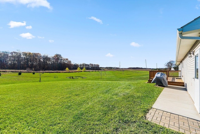 view of yard featuring a wooden deck and a rural view