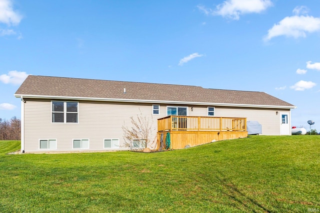 rear view of house with a wooden deck and a lawn