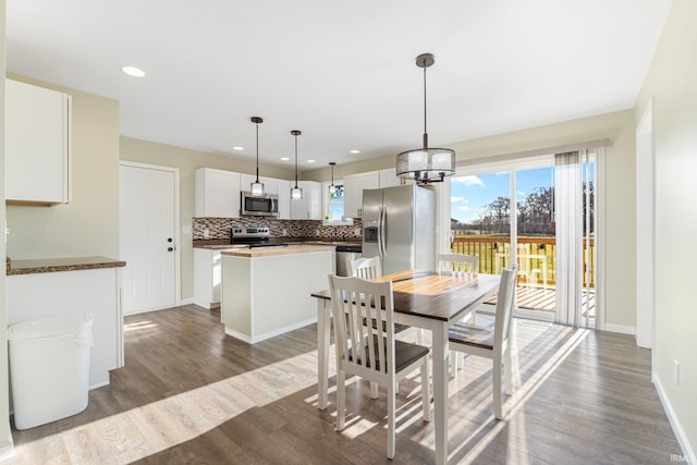 dining space featuring dark wood-type flooring and a chandelier