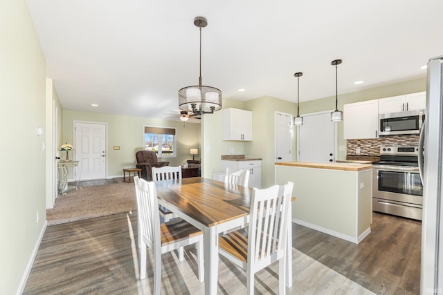 dining space featuring dark wood-type flooring and ceiling fan