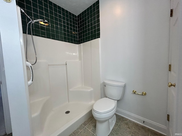 bathroom with tile patterned flooring, toilet, and a shower