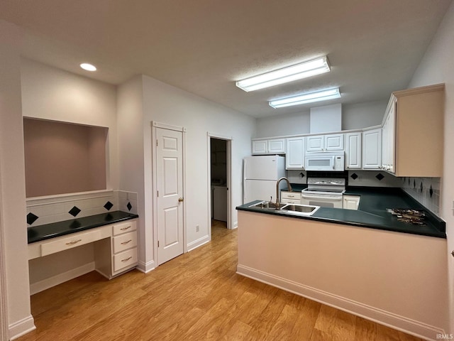 kitchen featuring sink, white cabinets, light hardwood / wood-style floors, kitchen peninsula, and white appliances