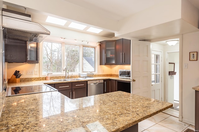 kitchen with sink, stainless steel dishwasher, light stone counters, dark brown cabinets, and black electric cooktop