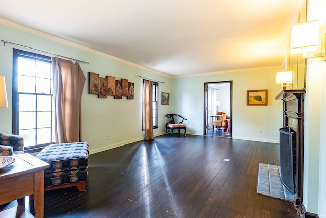 living room with crown molding, dark wood-type flooring, and a healthy amount of sunlight