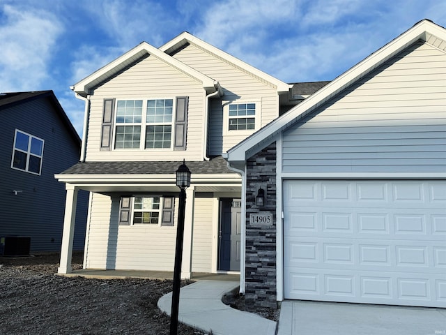 view of front of property with central AC unit and a garage