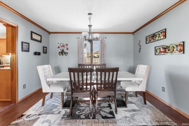 dining space with wood-type flooring, ornamental molding, a notable chandelier, and a textured ceiling