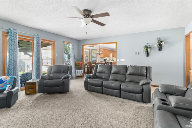 carpeted living room with a textured ceiling and ceiling fan