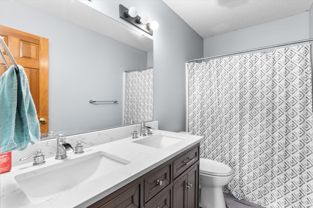 bathroom with vanity, a textured ceiling, and toilet