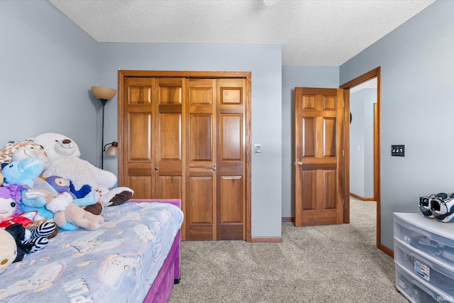 bedroom featuring light colored carpet, a closet, and a textured ceiling