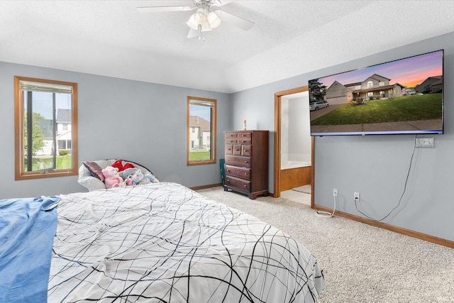 carpeted bedroom with ceiling fan, ensuite bath, and a textured ceiling