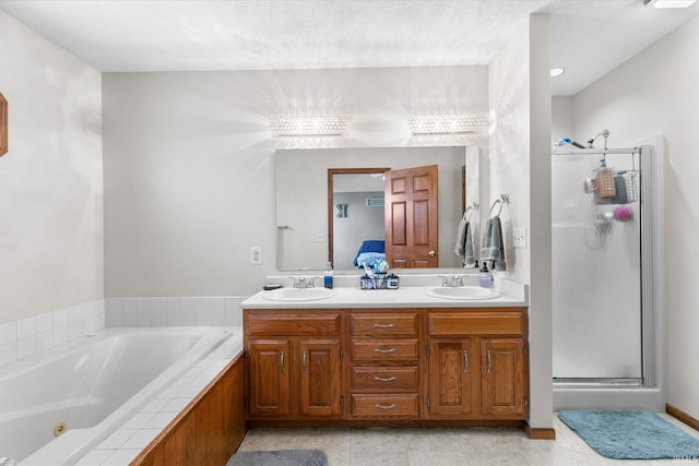 bathroom with vanity, shower with separate bathtub, tile patterned flooring, and a textured ceiling