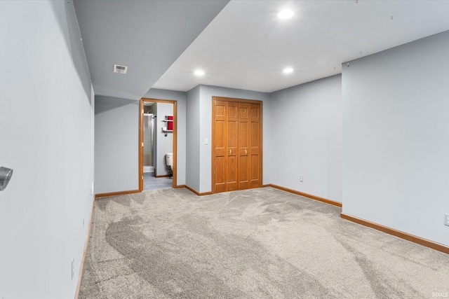 unfurnished bedroom with connected bathroom and carpet flooring