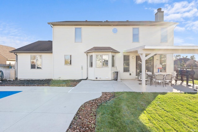 back of property with a lawn and a patio area